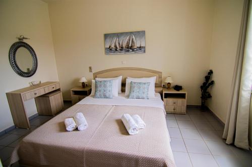 a bedroom with a bed with two towels on it at Castri Village Hotel in Palekastron