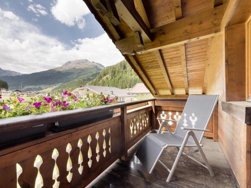 a chair on a balcony with a view of mountains at Apartment Kraxner in Sölden