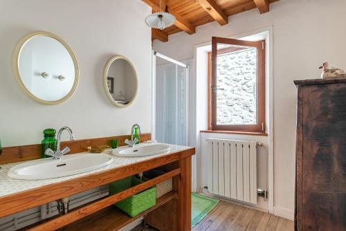 ein Badezimmer mit zwei Waschbecken und einem Spiegel in der Unterkunft Les Pieds dans la Beaume in Joyeuse