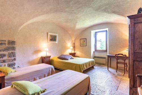 ein Zimmer mit zwei Betten und einem Fenster in der Unterkunft Les Pieds dans la Beaume in Joyeuse