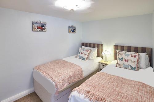 two beds in a room with white walls at Host & Stay - The Haven in Whitby