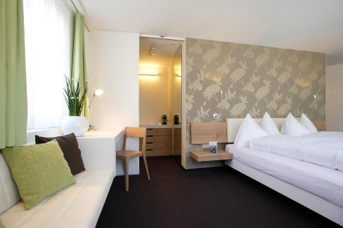 una camera con letto, scrivania e specchio di Anker Hotel Restaurant a Teufen