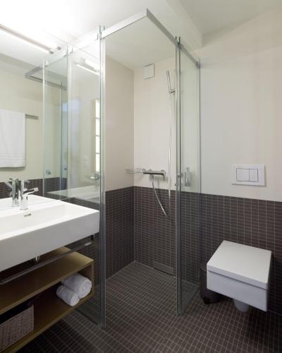 a bathroom with a shower and a sink and a toilet at Anker Hotel Restaurant in Teufen