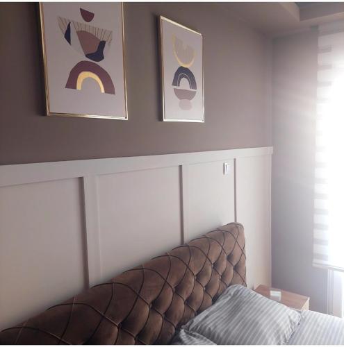 a bedroom with two pictures on the wall and a couch at Apartman Tadeus in Soko Banja