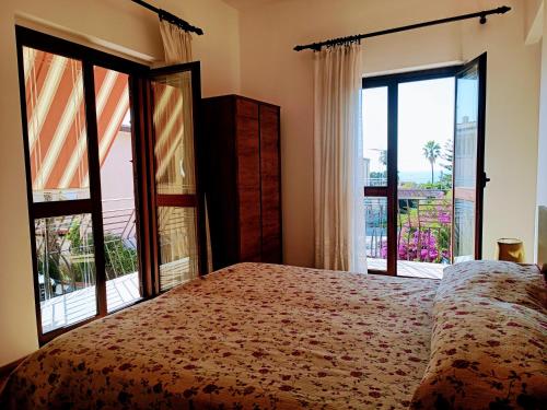 a bedroom with a bed and a large window at Appartamento Cavaliere Tropea in Tropea