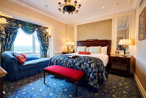 a bedroom with a bed and a chair and a window at Fairmont Grand Hotel Kyiv in Kyiv