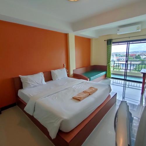 een slaapkamer met een groot bed en een balkon bij ธรดา in Ban Pa Kluai