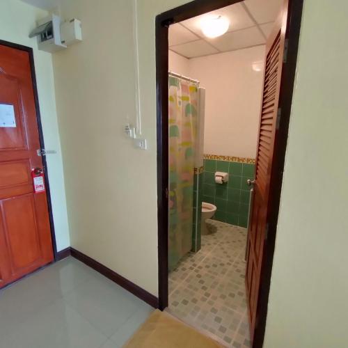 een badkamer met een douche, een toilet en een spiegel bij ธรดา in Ban Pa Kluai