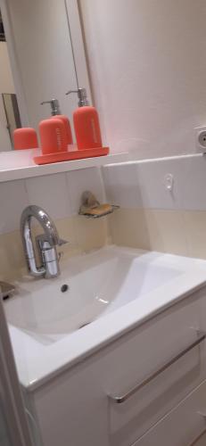 a bathroom sink with two red candles on a shelf at Studio aux pieds des pistes Roche Béranger in Chamrousse