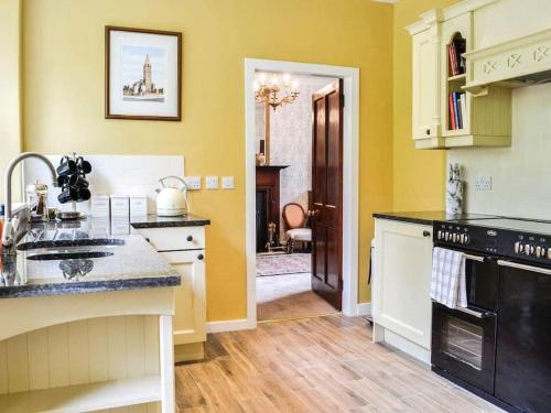 une cuisine avec un évier et une cuisinière four supérieur dans l'établissement Beautiful Traditional secluded country cottage, à Sanquhar