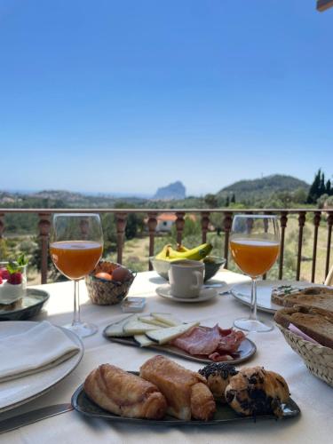 Villa Riu Blanc في بينيسا: طاولة مع الطعام وكأسين من النبيذ