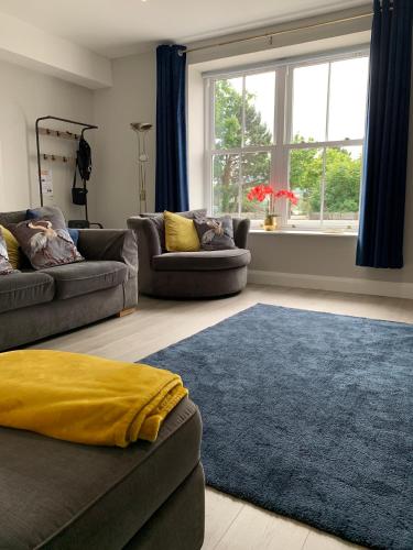 a living room with two couches and a blue rug at Seaview Aurora House - Central Luxury Apartment in Warrenpoint