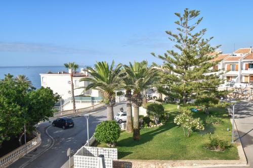un balcón con vistas a la calle y a las palmeras. en Vicino al mare en Santa Pola