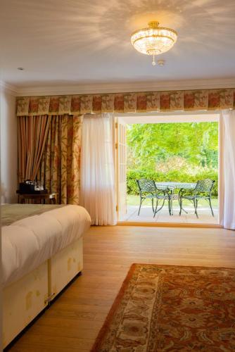 a bedroom with a bed and a window and a table at The Dixcart Hotel in Sark