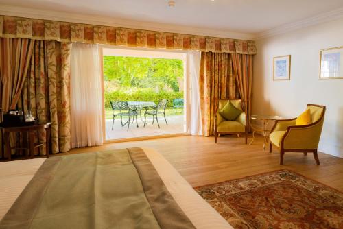 a bedroom with a large window and a table and chairs at The Dixcart Hotel in Sark