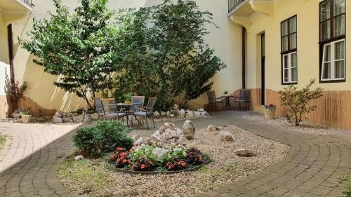 a garden area with a table, chairs, and plants at Central Hotel 21 and Apartments in Budapest