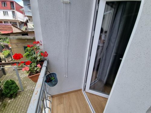 an open door to a balcony with flowers on it at Apartment By The Sheraton in Batumi