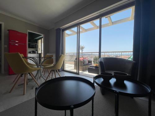 salon ze stołem i krzesłami oraz dużym oknem w obiekcie RoofTop Apartement - Quartier Croisette - Esc'Appart w Cannes