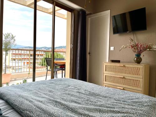 sypialnia z łóżkiem i telewizorem oraz balkonem w obiekcie RoofTop Apartement - Quartier Croisette - Esc'Appart w Cannes
