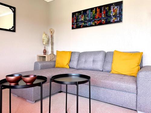 a living room with a gray couch and two tables at RoofTop Apartement - Quartier Croisette in Cannes