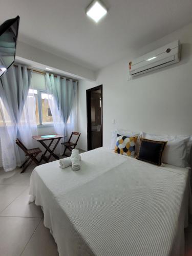 - une chambre avec un grand lit blanc et une table dans l'établissement Apartamentos da Gaby, à Morro de São Paulo