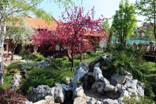a garden with rocks and trees in front of a building at Hotel Centar Balasevic in Belgrade