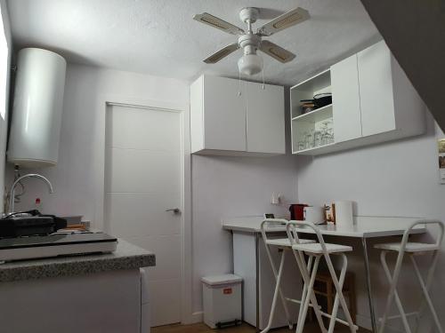 a kitchen with white cabinets and a ceiling fan at Finca Eva 34 Casares Historico in Casares