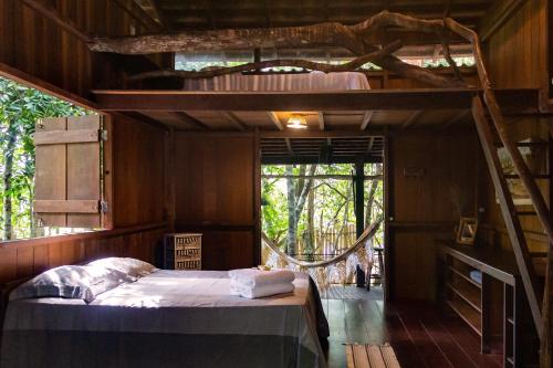 a bedroom with a bed in a tree house at Bangalô Ponta de Areia, na beira da praia in Alter do Chao