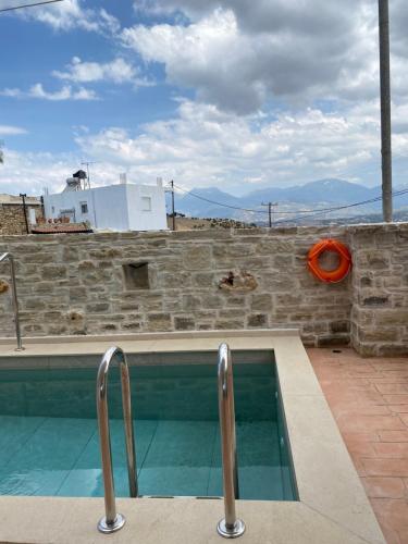 a swimming pool on top of a building with mountains in the background at Halkidio House in Sívas