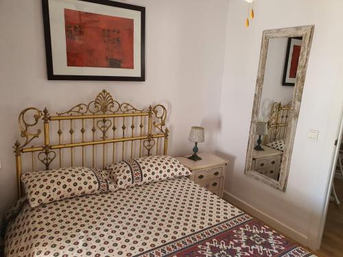 a bedroom with a bed and a mirror on the wall at Finca Eva 34 Casares Historico in Casares