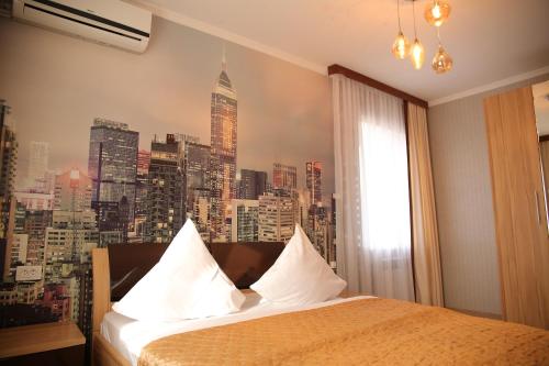 a bedroom with a city skyline mural on the wall at Sweet Home Hotel in Atyrau