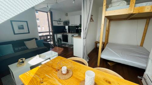 ein Wohnzimmer mit einem Esstisch und einem Etagenbett in der Unterkunft Appartement 4 personnes Puy St Vincent 1700 in Puy-Saint-Vincent