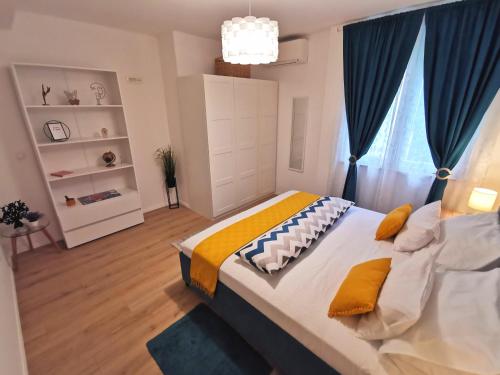ein Schlafzimmer mit einem großen Bett mit gelben und blauen Kissen in der Unterkunft Apartment Blue Dream in Dubrovnik