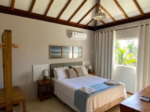 a bedroom with a bed and a large window at KORA MAR - Taipu de Fora - BA in Barra Grande