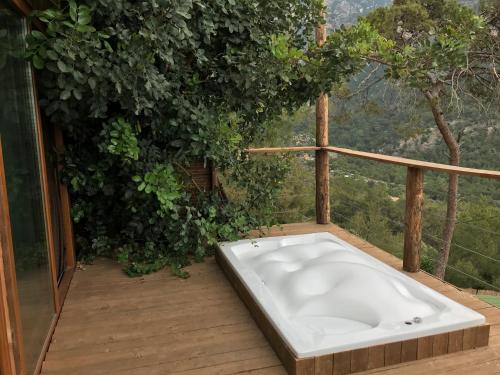 a bath tub sitting on a deck next to a window at Kabak Ütopya Kamp in Faralya
