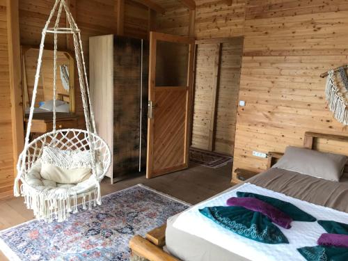 a bedroom with a bed and a swing at Kabak Ütopya Kamp in Faralya