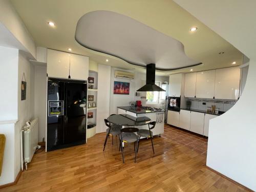 a kitchen with a table and a black refrigerator at Riviera Apartment in Constanţa