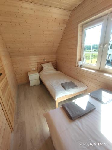 a small room with two beds and a window at Plażowisko in Dębki