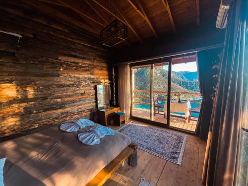 a bedroom with a bed and a large window at Kabak Ütopya Suites in Faralya