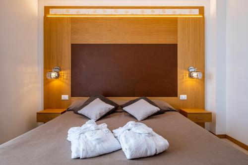 a bed with two towels sitting on top of it at Hotel Mare in Lignano Sabbiadoro