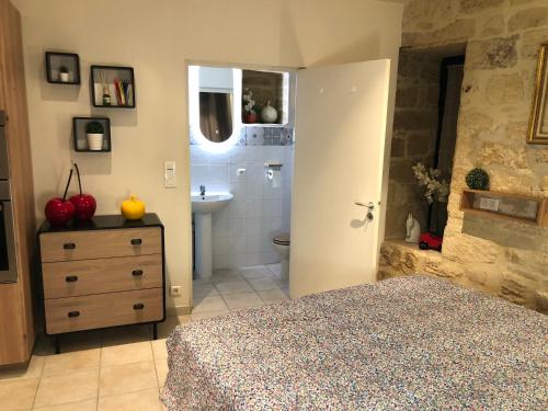 une chambre avec un lit et une salle de bain avec un lavabo dans l'établissement La Venelle, à Sarlat-la-Canéda