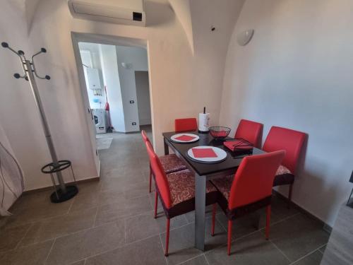 a dining room with a table and red chairs at Chez Gabry in Sanremo