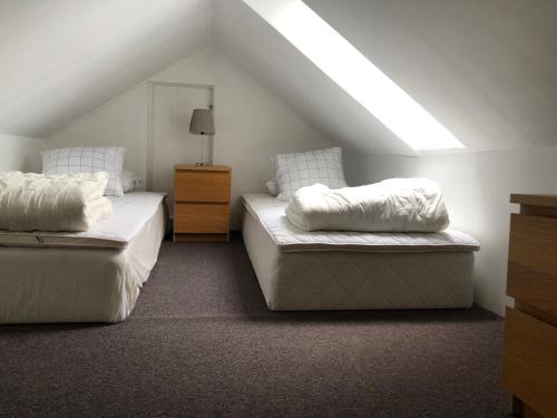 a attic bedroom with two beds and a window at Lillstugan in Skara