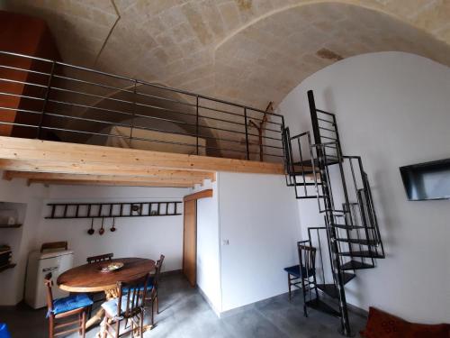 um quarto com uma mesa de madeira e uma escada em espiral em B&b la vecchia corte em Copertino
