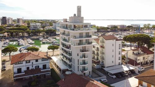 an aerial view of a white building with a marina at Hotel Mare in Lignano Sabbiadoro