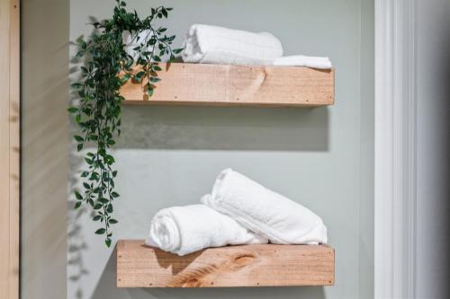 a bathroom with two wooden shelves with towels at Modern home with a pool sauna pooltable & mountain view in Collingwood
