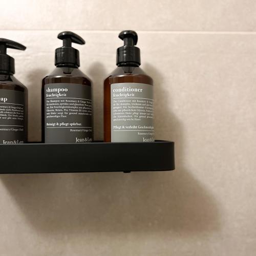 a shelf with three shampoo bottles on it at La Dama del Porto in Laveno-Mombello