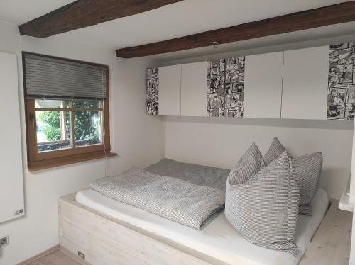 a bed in a room with a window and pillows at Ferienwohnung Gradeberg in Überlingen