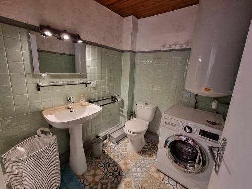 La salle de bains est pourvue d'un lavabo et d'un lave-linge. dans l'établissement appartement 2 chambres, à Maureillas