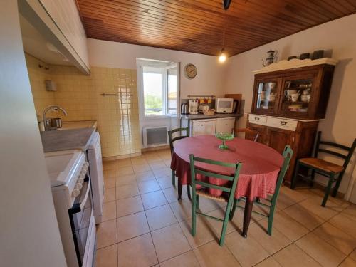 a kitchen with a red table and chairs in a room at appartement 2 chambres in Maureillas